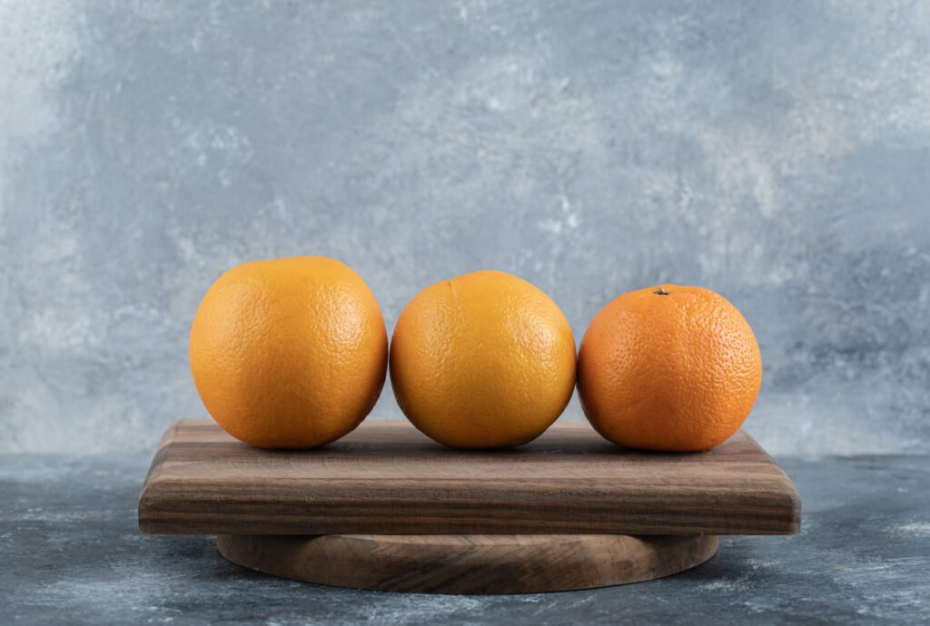 ripe fresh oranges on wooden board