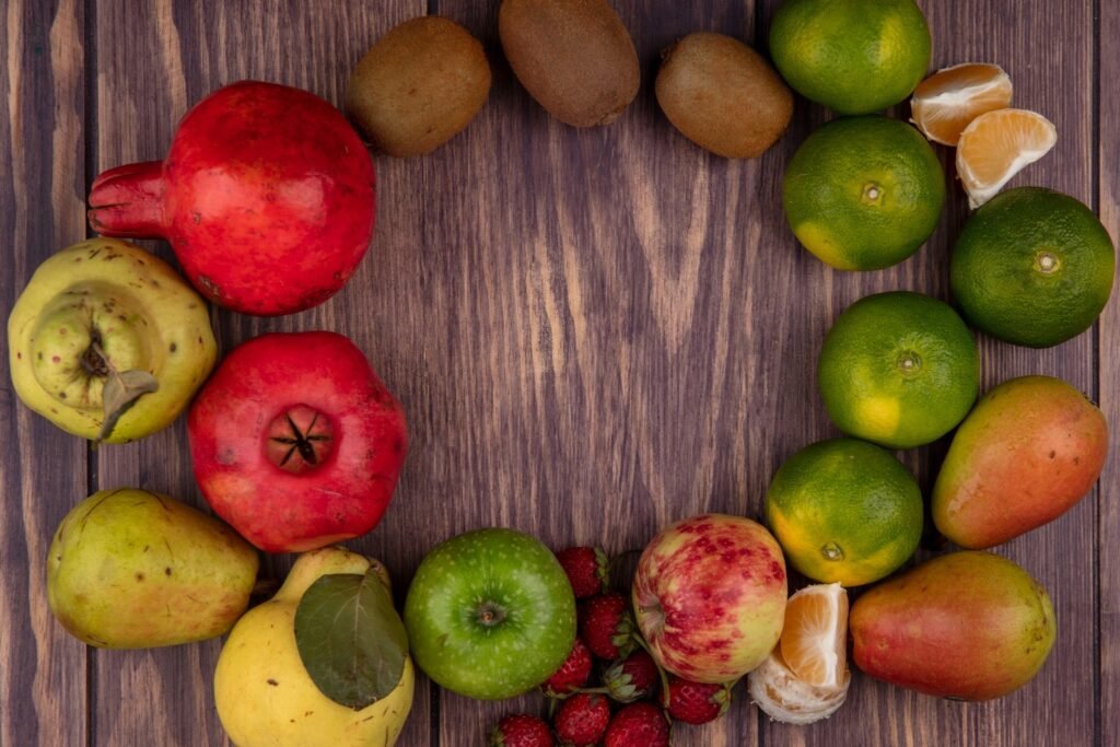 top view copy space colored apples with kiwi tangerines pears strawberries pomegranates wooden wall
